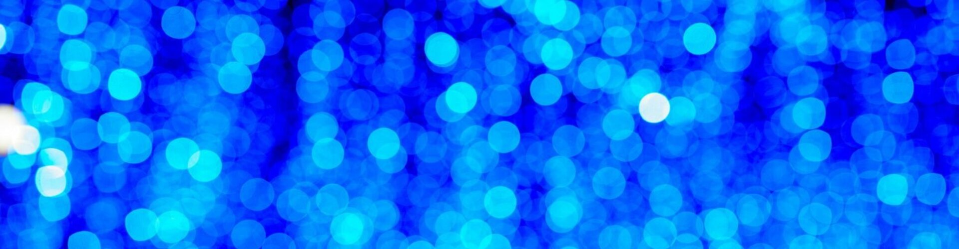 Blaue verschwommene Lichtpunkte vor einem dunklen Hintergrund
