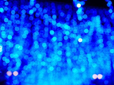 Blaue verschwommene Lichtpunkte vor einem dunklen Hintergrund