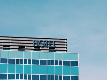 TÜV prüft Hygiene und Infektionsschutz in Hotels und Gaststätten Fassade eines Hotels vor blauem Himmel