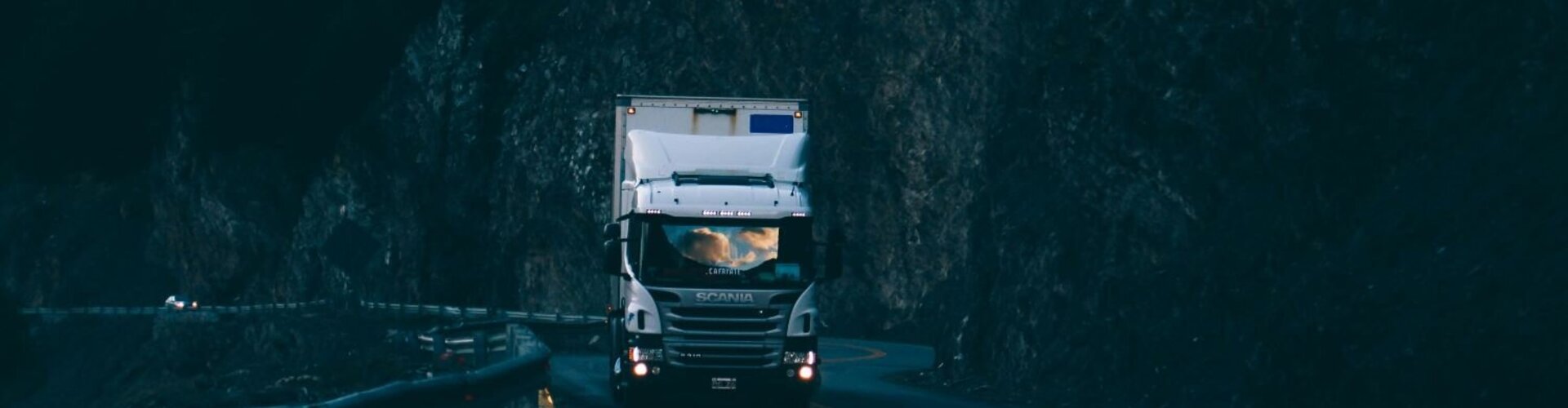 Ein Sattelschlepper fährt in der Dämmerung ein steiles Autobahnstück hinauf