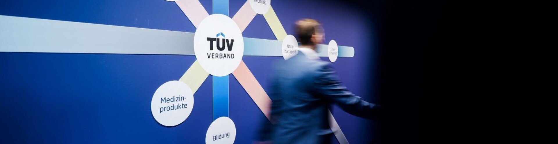 Eine Person schreitet durch einen vollständig blauen Flur in der neuen Geschäftsstelle des TÜV-Verbands