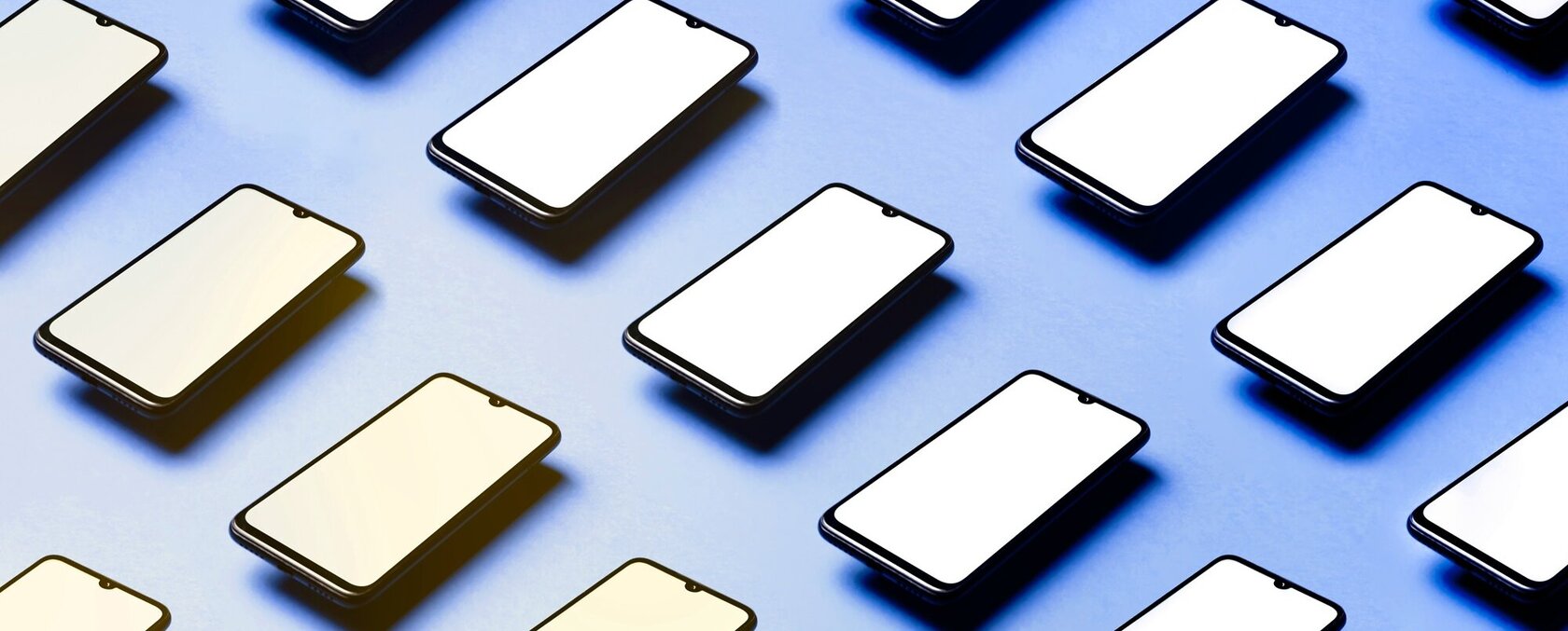 Diverse Smartphones liegen parallel nebeneinander angeordnet auf einem blauen Untergrund