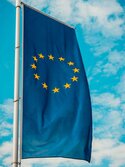 Die EU-Fahne weht vor Schäfchenbewölktem Himmel