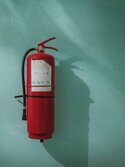 Roter Feuerlöscher, der an einer Wand hängt