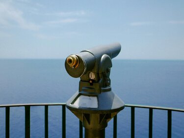 Blick auf das Meer von einer Ausblicksplattform mit einem Fernglas 
