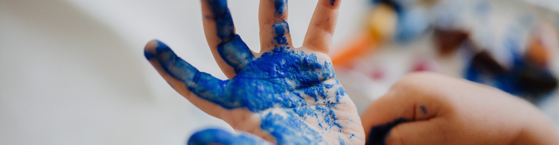 TÜV-Verband: Fingermalfarben können Gesundheit schädigen Kinderhand mit blauer Fingermalfarbe