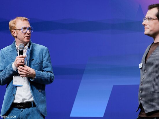 © Tobias Koch Dr. Joachim Bühler, Geschäftsführer TÜV-Verband, und Dr. Patrick Gilroy, Referent Weiterbildung und KI, halten die Schlussworte der AICon 2025