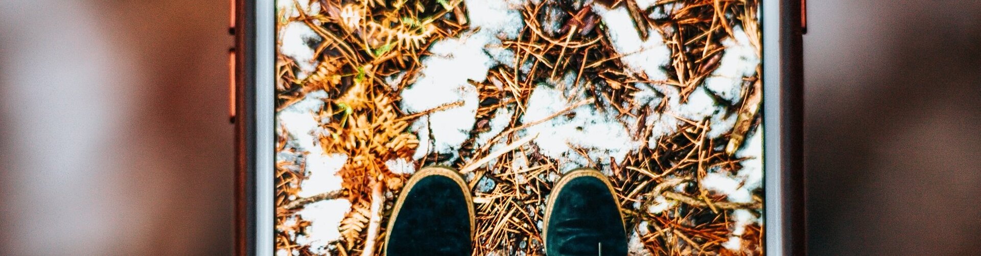 So schützen Handy-Nutzer:innen den Akku vor Frost und Kälte Mann man ein Foto der eigenen Beine und Füße mit dem Smartphone