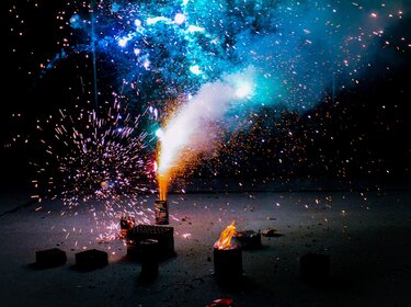 Funken sprühen aus Standfeuerwerk auf dunkler Straße