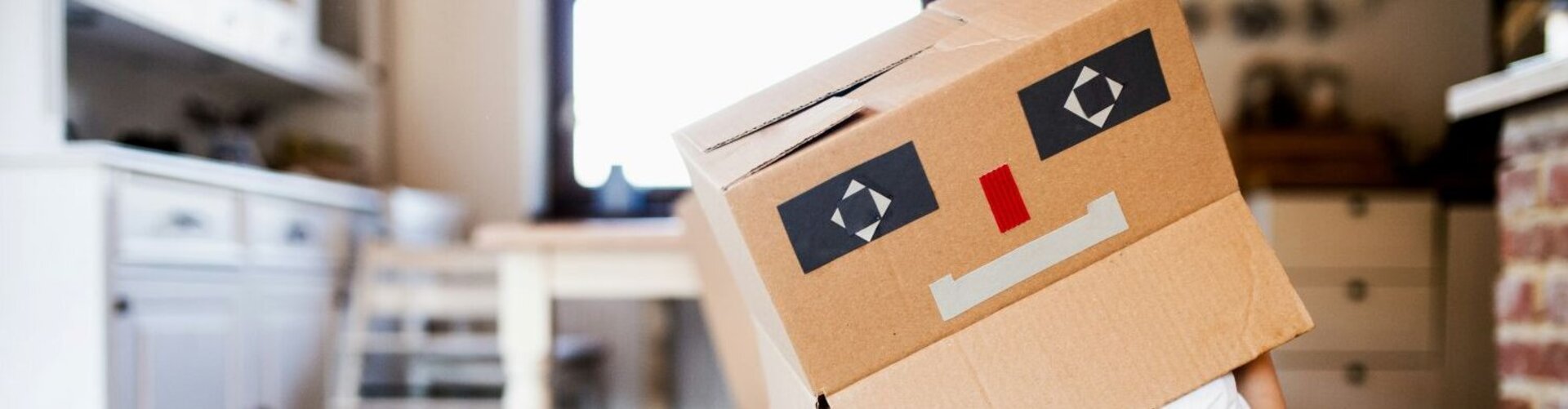 Ein Kind hat sich mit einem bemalten Karton als Roboter verkleidet