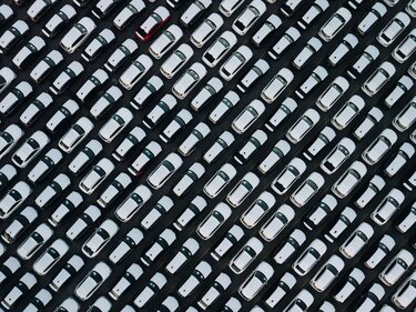 Hunderte weiße Neuwagen stehen auf einer Asphaltfäche