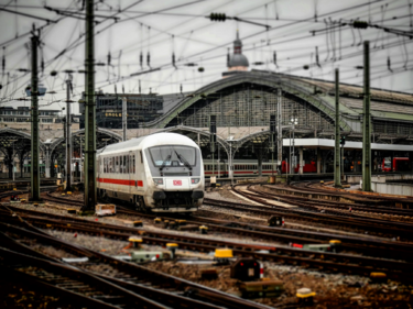 Digitalisierung der Schiene: Verfahren modernisieren! Zug der Deutschen Bahn fährt aus einem Bahnhof heraus.