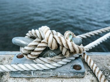 Ein Tau ist am Hafen fest verknotet