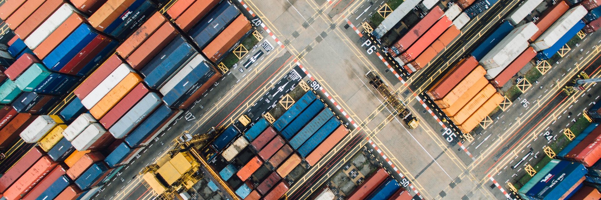 Blick von oben auf einen großen Hafen mit bunten Containern